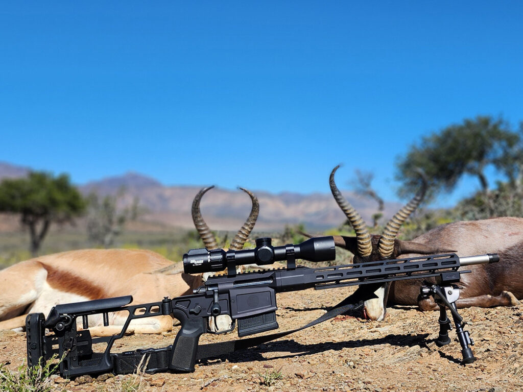 The Sig Sauer CROSS rifle laying in front of two dead Springboks.